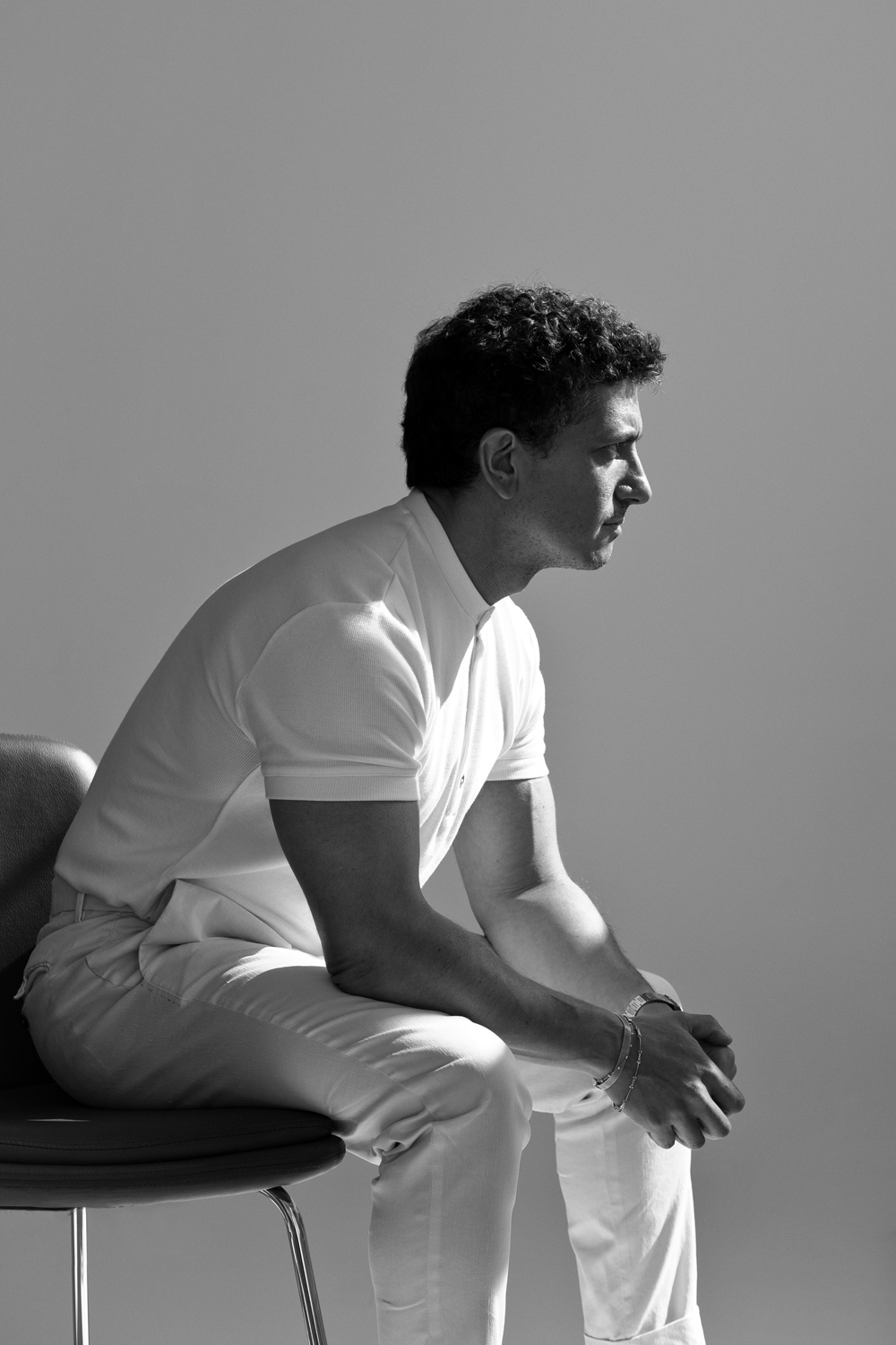Matteo Russo seated in profile in a white polo